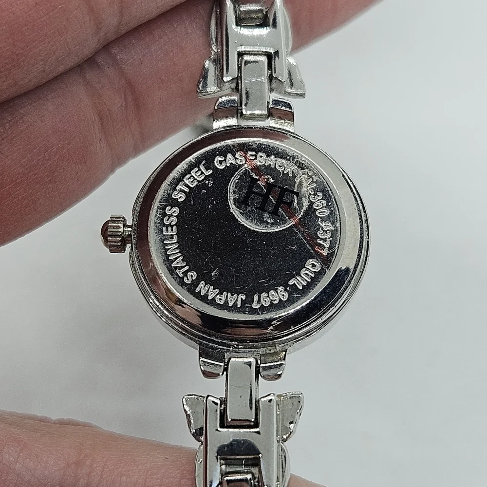small silver tone watch with purple face and rhinestone butterflies